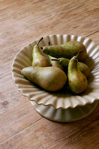 Pears on a decorative ceramic plate on a wooden surface