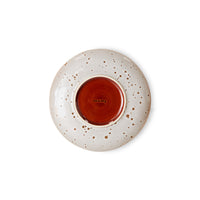 Speckled ceramic plate with a red interior on a white background