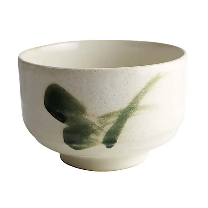 Ceramic bowl with green abstract design on a white background