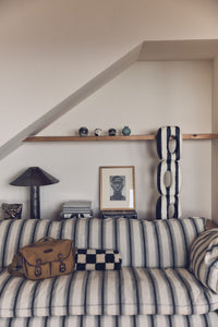 Striped sofa with decorative items against a white wall