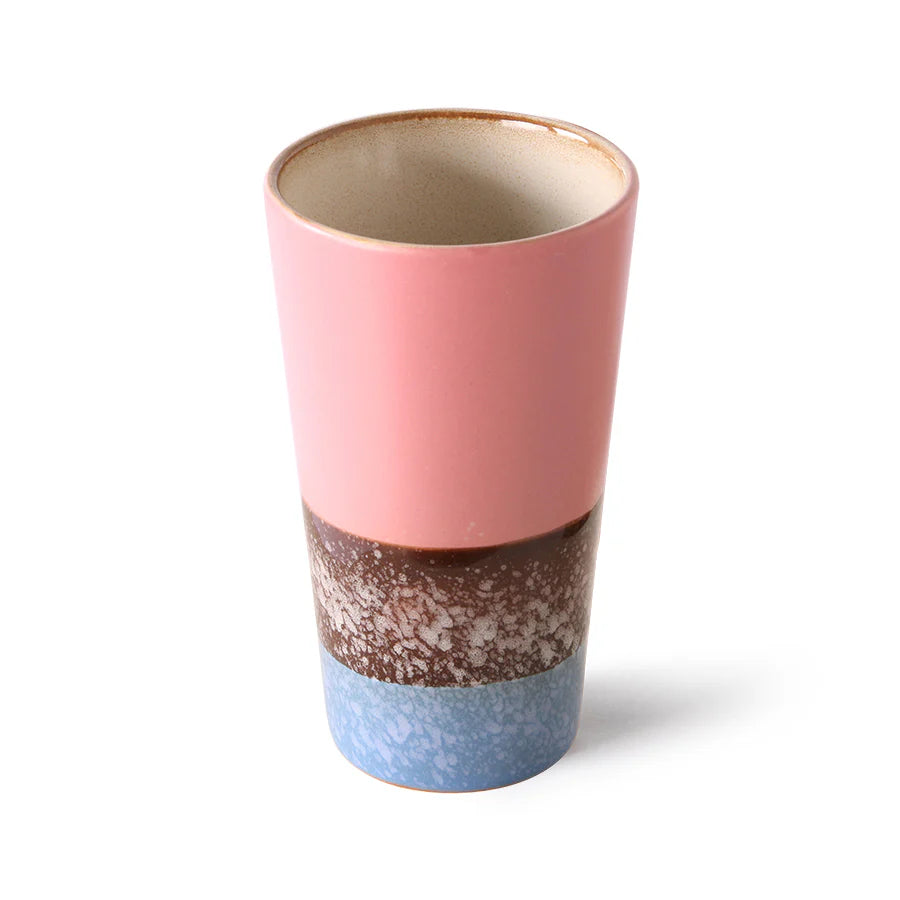 Multicolored ceramic cup with a gradient from pink to brown to blue on a white background