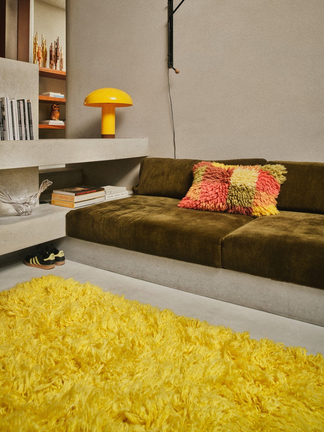 yellow area rug, green sofa and yellow table lamp