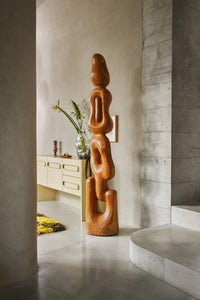 teak wooden tall organic shape artwork totem in hallway