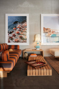 living room with orange and brown striped sofa and framed photo art on wall