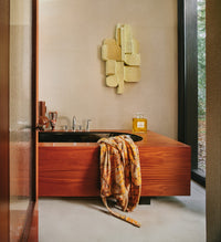 3D wall sculpture hanging in bathroom with wood bathtub