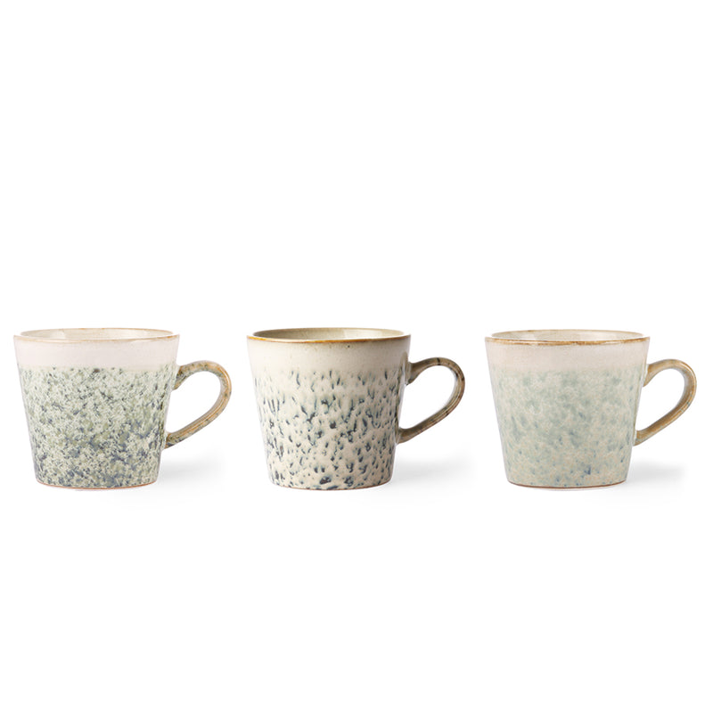 Three ceramic mugs with speckled design and brown rims on a white background