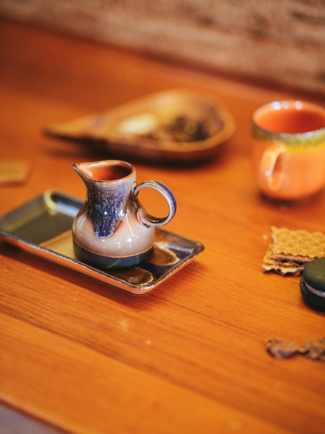 retro style creamer in brown tones with reactive glaze finish and texture on small tray