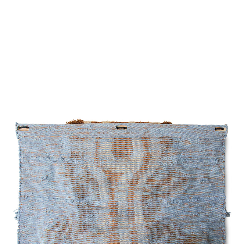 backside of blue and brown textured wall hanging rug