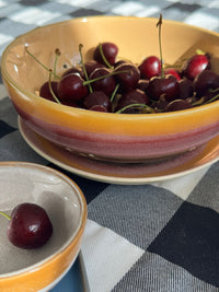 Bowl of cherries on a checkered fabric background