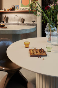 green colored bulb stemless glass on table with chess board