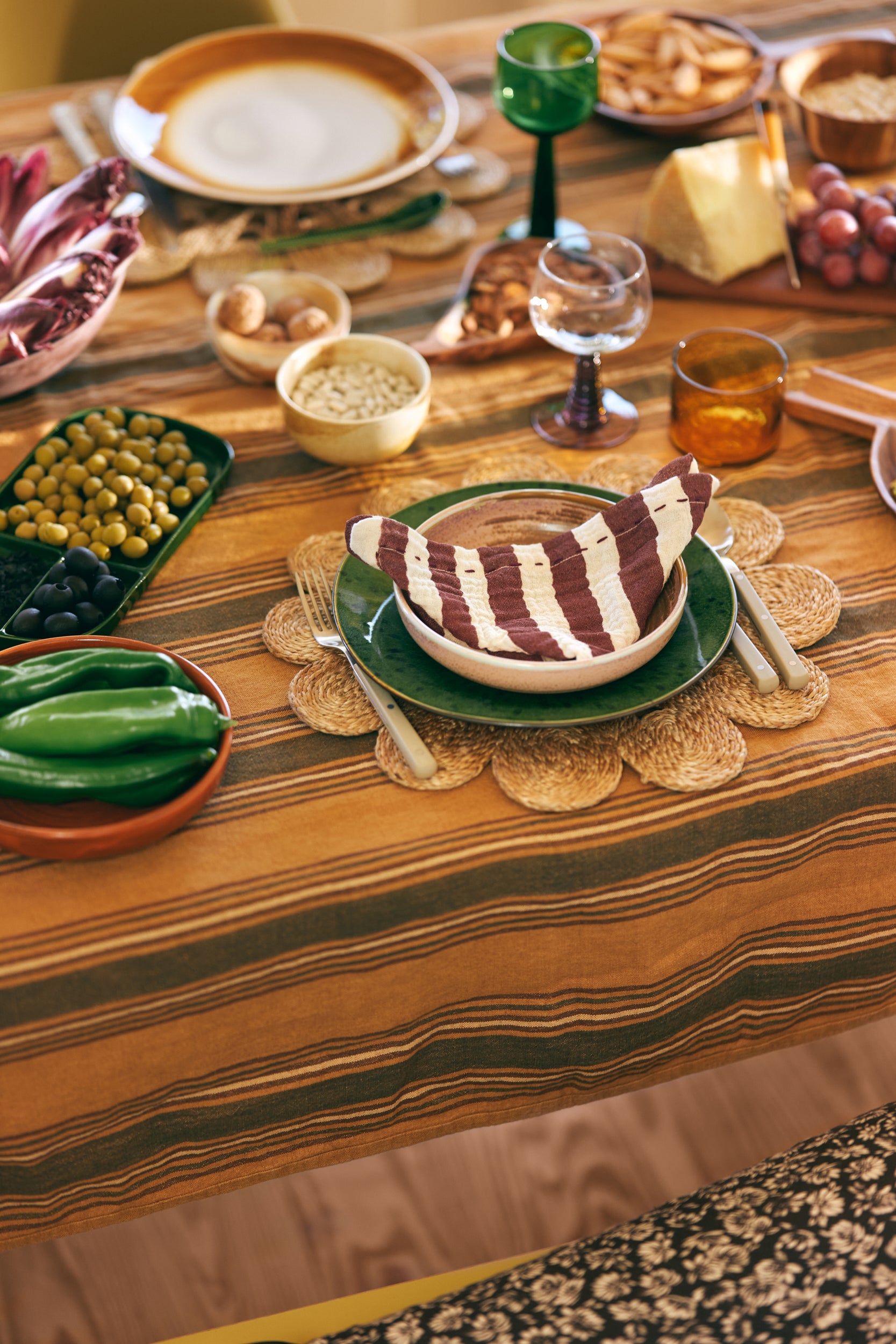 green plate, olive green fork and knife and striped napkin