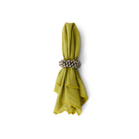 Green napkin with a decorative silver ring on a white background