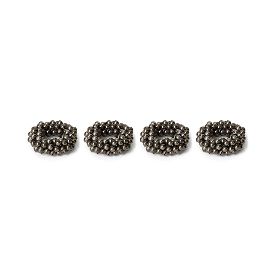 Four metallic beaded napkin rings on a white background