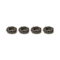 Four metallic beaded napkin rings on a white background