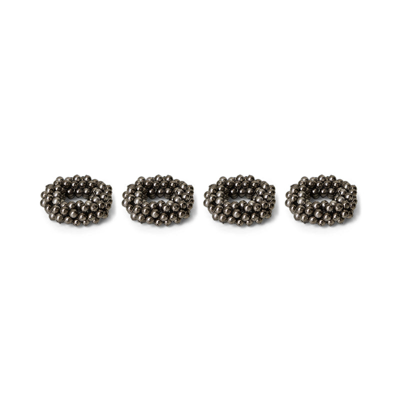 Four metallic beaded napkin rings on a white background