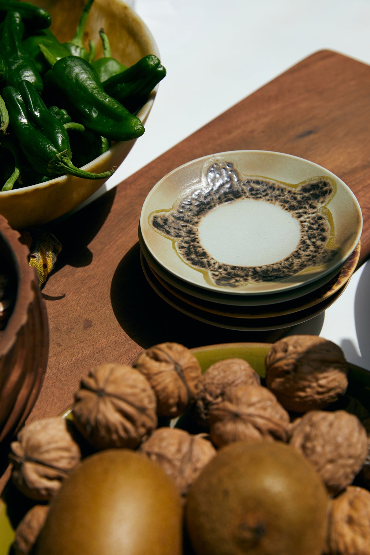 stack of saucers an table with walnuts