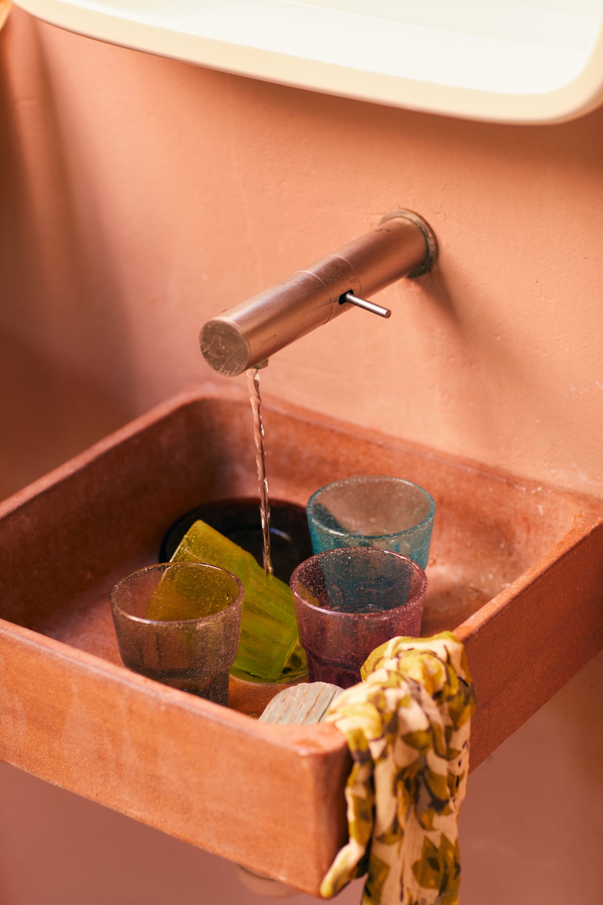 6 different color glasses in sink