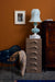 mocha brown set of drawers with aqua blue and white glass table lamp