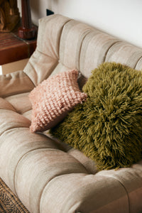 blush pink and green fluffy pillows on sofa