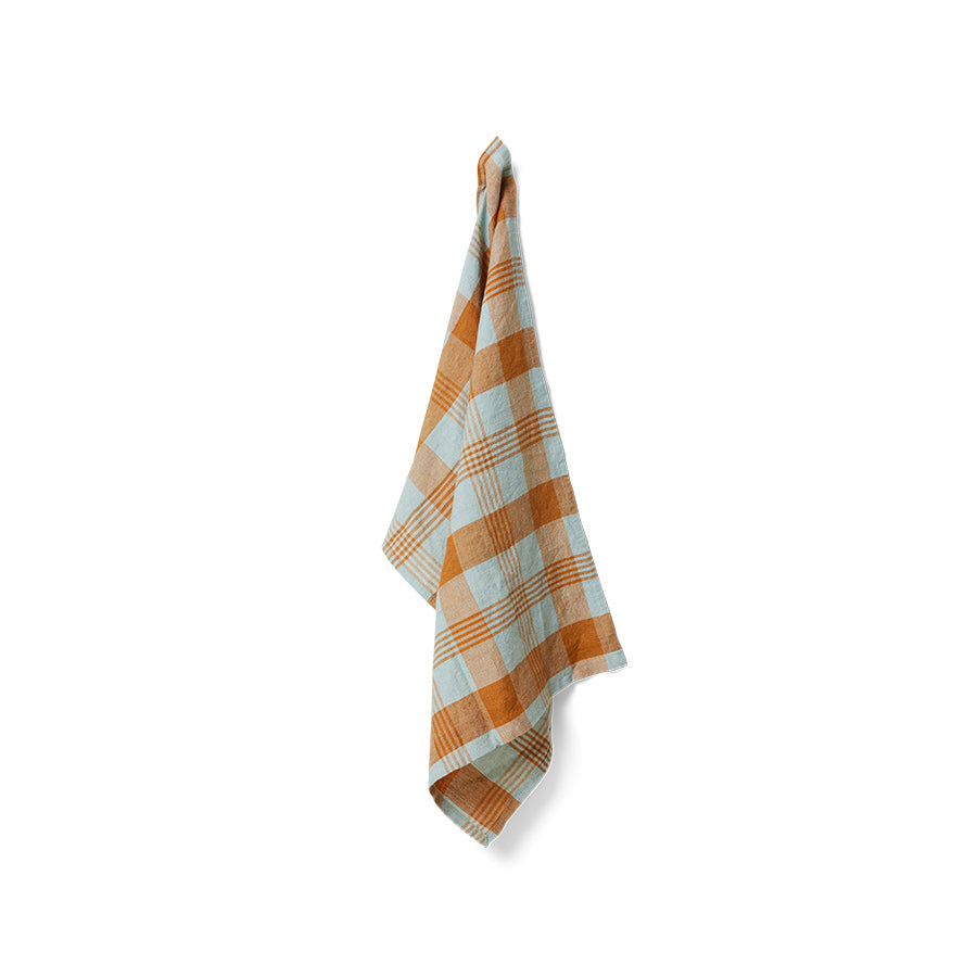 Plaid towel with orange and white pattern on a white background