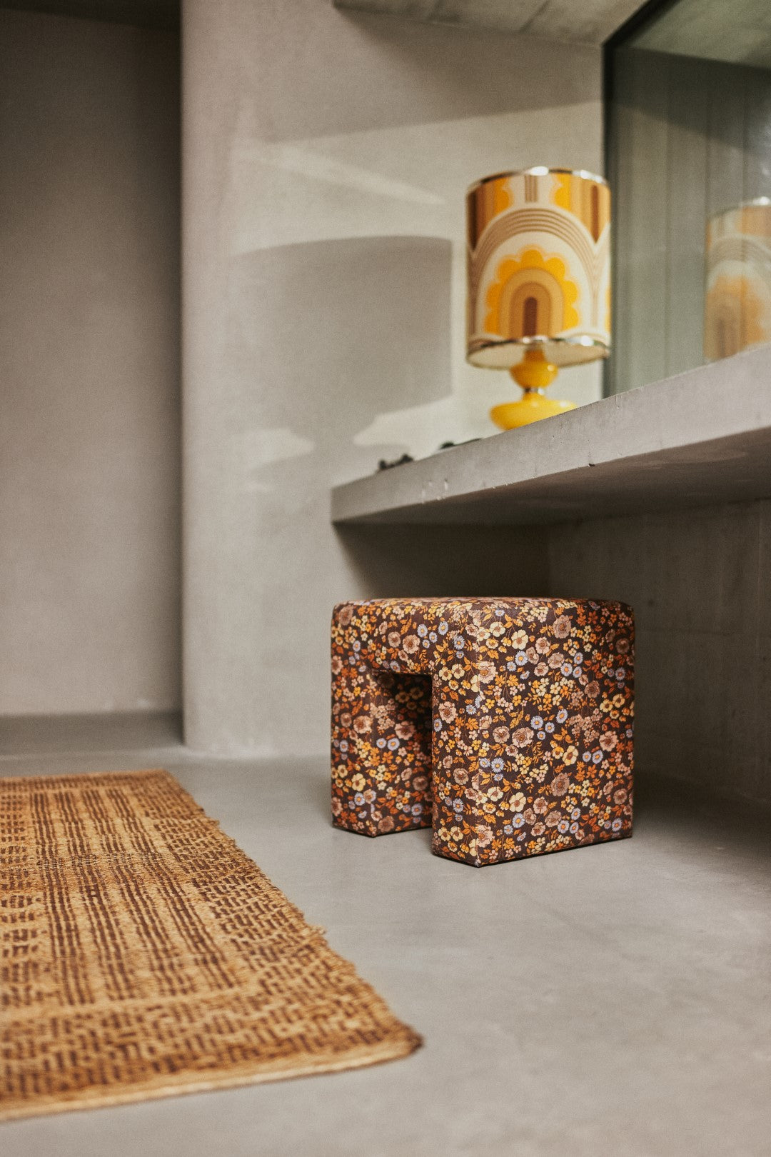 ottoman stool brown flower fabric with concrete vanity and yellow table lamp