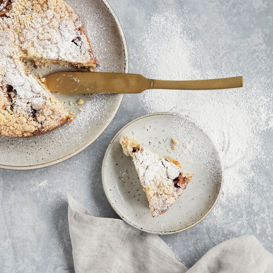 gold colored cake serving knife with apple pie