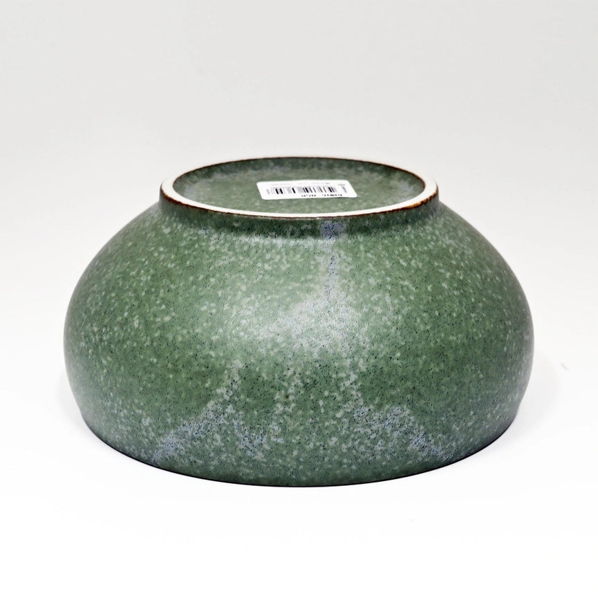 Green ceramic bowl with speckled texture on a white background