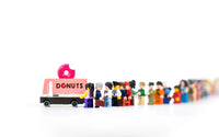 Model of a 'Donuts' truck with a line of Lego figures in front on a white background