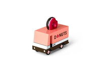 Toy donut truck with a donut on top against a white background