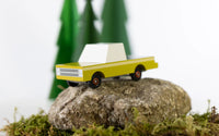 Toy truck on a rock with greenery in the background