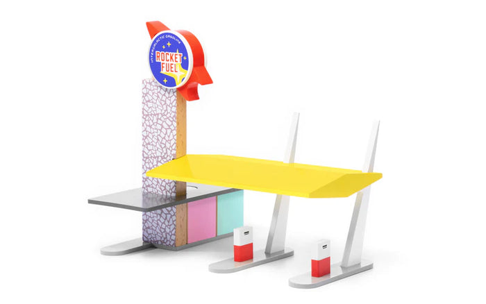 Colorful miniature model of a gas station with a yellow car on a white background