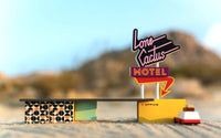 Model of a motel with a neon sign in a desert setting