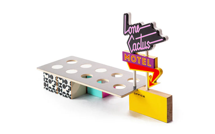 Colorful miniature model of a motel sign with 'Lone Cactus Motel' on a white background