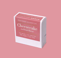 Box of cheesecake-flavored product on a pink background