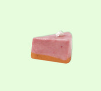 Pink cheesecake slide on a light green background
