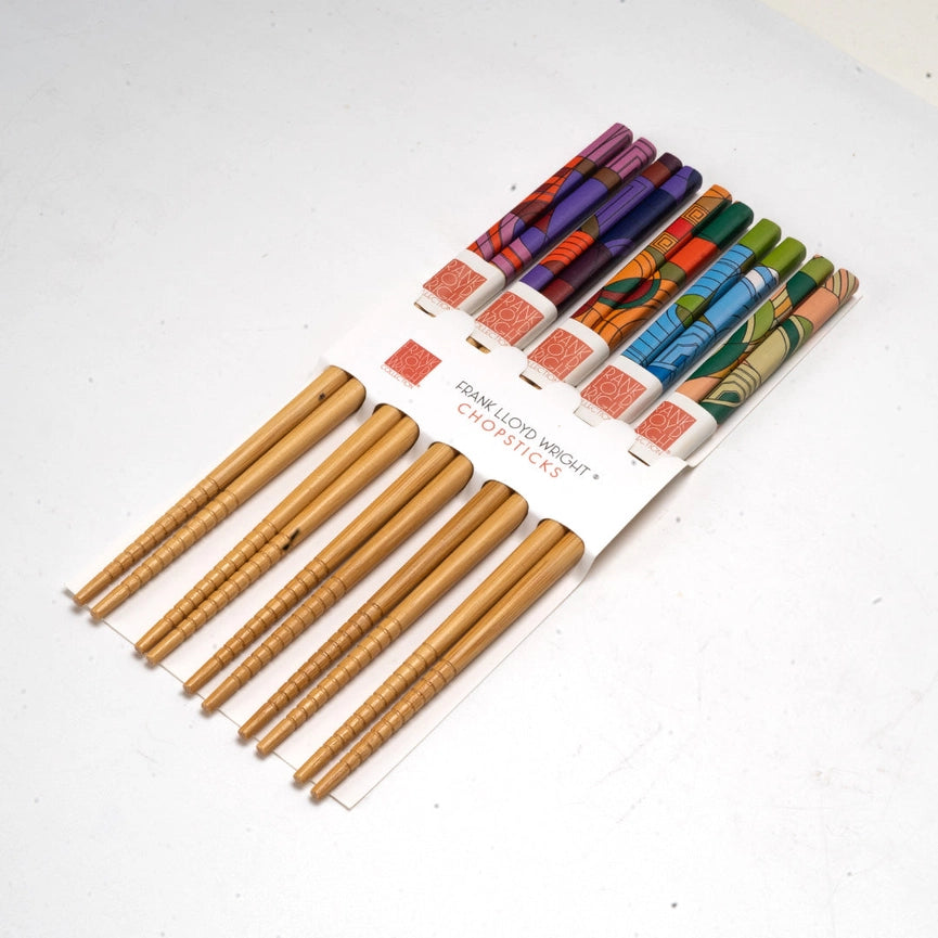 Set of wooden chopsticks with colorful packaging on a white background