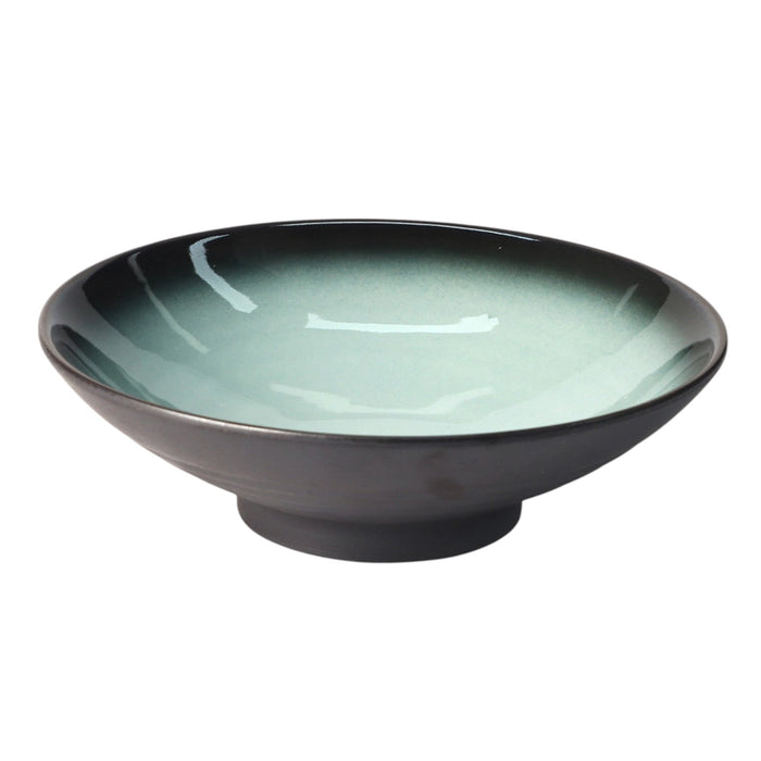 Teal ceramic bowl on a white background