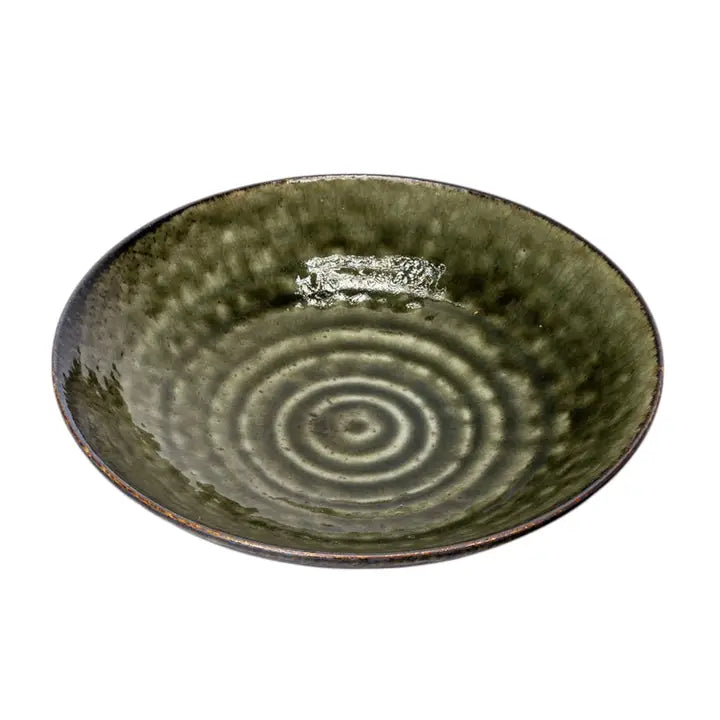 Green ceramic bowl with concentric circle pattern on a white background
