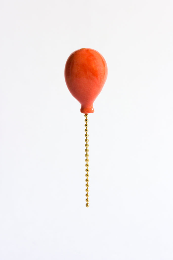 Orange pull chain light bulb on a white background