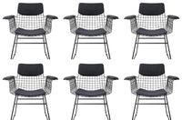 Six black wireframe chairs with black cushioned seats on a white background
