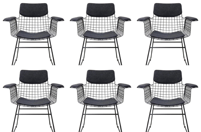 Six black wireframe chairs with black cushioned seats on a white background