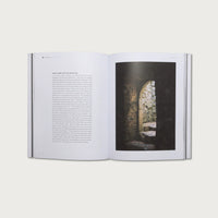 Open book with text on one page and a photograph of a stone archway on the other, on a white background.