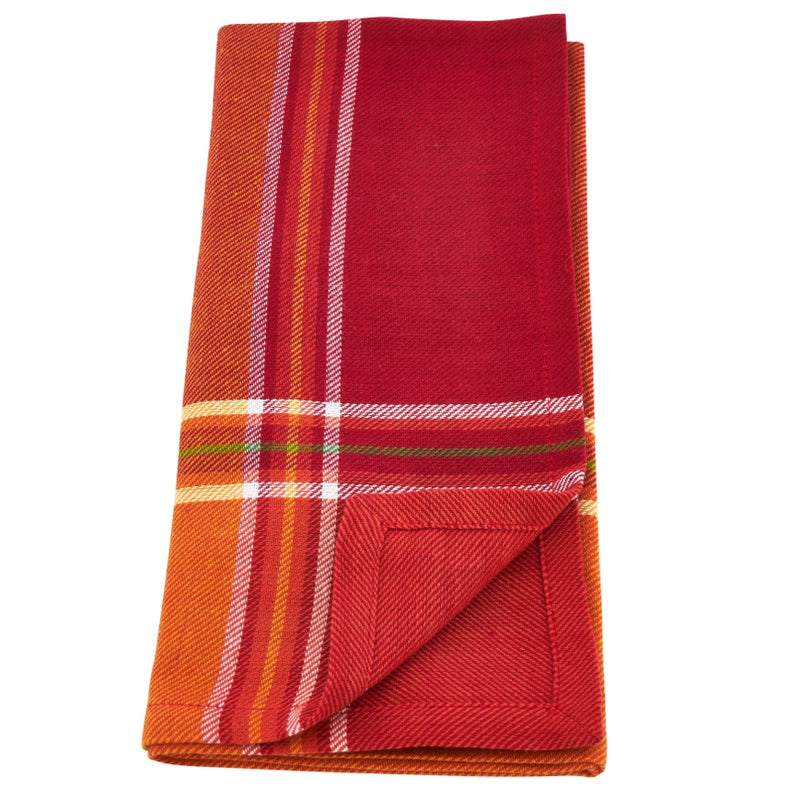 Folded red and orange plaid blanket on a white background
