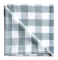 Folded checkered fabric napkin on a neutral background
