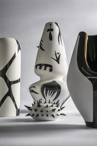 Three ceramic vases with black abstract patterns on a gray background