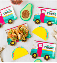 Colorful taco-themed table setting with truck designs and 'Time for Tacos' text on a white surface.