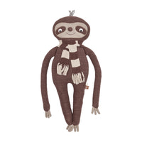 Knitted sloth toy with a scarf on a white background