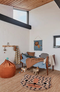 Children's bedroom with a lion-themed rug, bed, and bean bag.