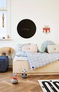 Children's bedroom with a bed, toys, and wall decorations.