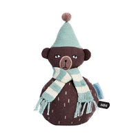 Stuffed bear toy with a green hat and scarf on a white background